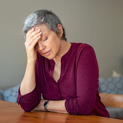 sitting-at-table-with-headache-sq